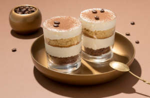 A beautifully plated Gordon Ramsay alcohol-free tiramisu, layered with creamy mascarpone and cocoa powder, served in a glass dish.