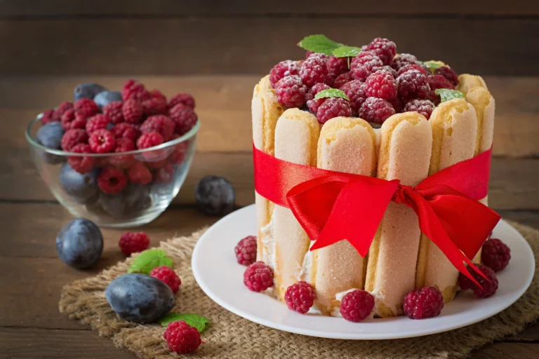 A classic Charlotte Russe dessert showcasing ladyfingers, creamy filling, and fresh berries elegantly arranged.