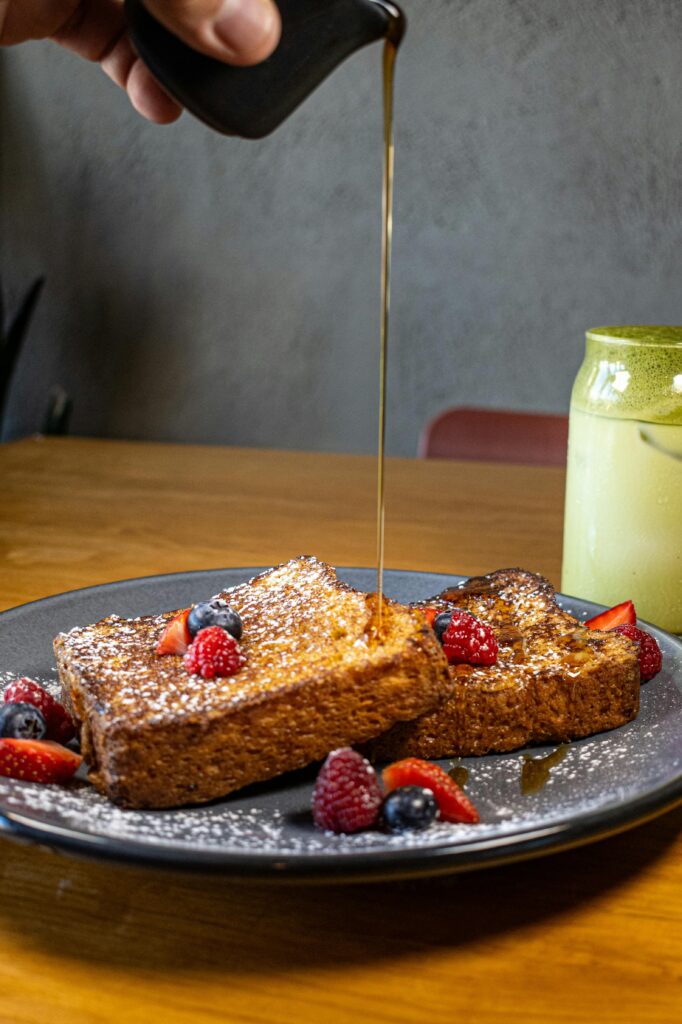 A skillet cooking slices of sourdough French toast, sizzling in melted butter