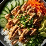 Plate of Bang Bang Chicken Bowl with vibrant vegetables and spicy sauce