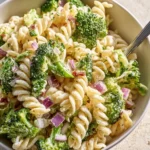 Delicious best broccoli pasta salad served in a bowl with colorful vegetables.