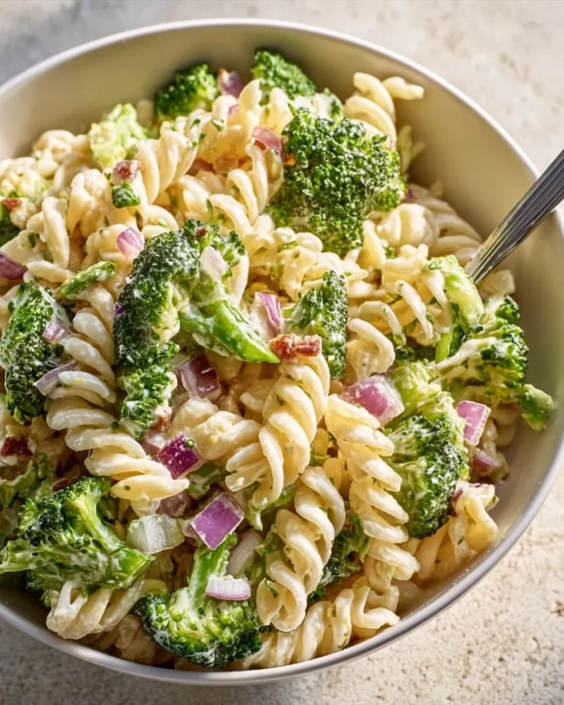 Delicious best broccoli pasta salad served in a bowl with colorful vegetables.
