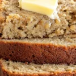 Slice of easy moist banana bread on a wooden cutting board