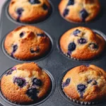 Freshly baked hearty blueberry protein muffins with a golden brown top.