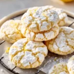 Plate of freshly baked Lemon Crinkle Cookies dusted with powdered sugar