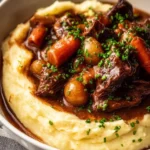 Bowl of classic beef bourguignon with vegetables and herbs