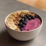 High protein breakfast smoothie bowl topped with fruits and nuts
