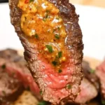 Delicious Cowboy Butter Steak sizzling on a grill with flavorful toppings.