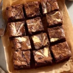 Fudgy cheesecake brownie with a rich chocolate base and creamy topping