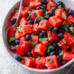 Bright and colorful Honey Lime Mint Watermelon Berry Fruit Salad in a bowl