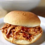 Delicious crockpot BBQ chicken served in a bowl with fresh herbs